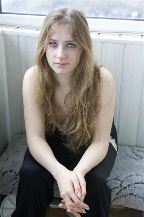 serious teen girl with long hair sitting stock image