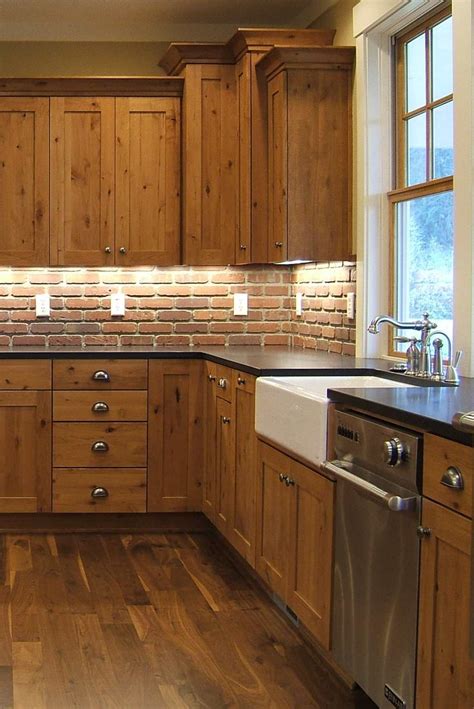 rustic kitchen vintage cabinetry brick backsplash honed black granite dark hardwood floor