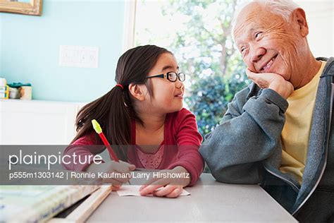 Japanese Grandfather Helping Granddaughter With Homework Stock Image