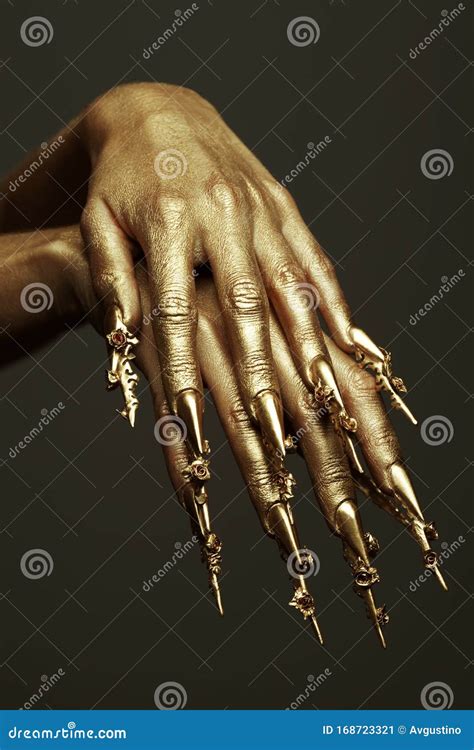beautiful golden hands  golden long arty nails close  stock