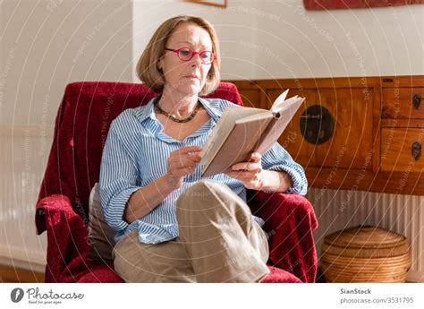Elegant Mature Woman Is Reading A Book At Home A Royalty