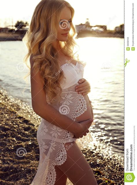 beautiful pregnant woman with long blond hair posing on