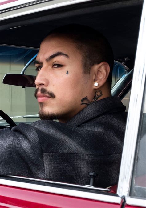 a man with tattoos sitting in a car