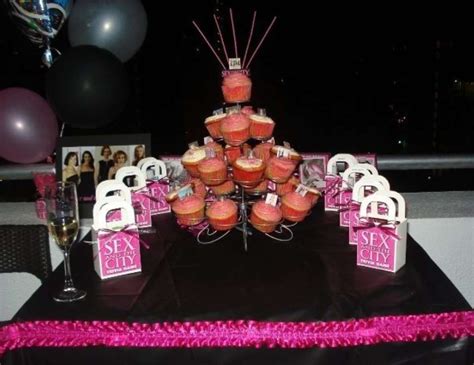a table topped with lots of cupcakes covered in frosting and pink