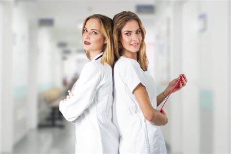 Free Photo Two Pretty Young Women Doctors Nurses Standing Back To