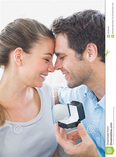 Happy Couple Getting Engaged On The Sofa Stock Image