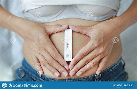 Woman Holding Positive Pregnancy Test With Heart Shape