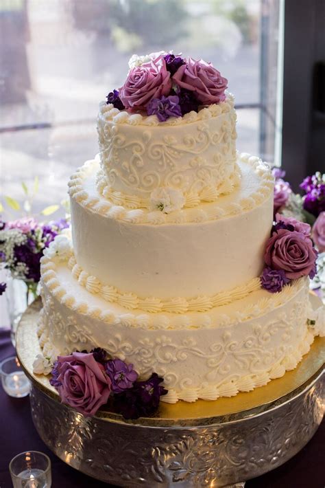 three tier white wedding cake purple flowers