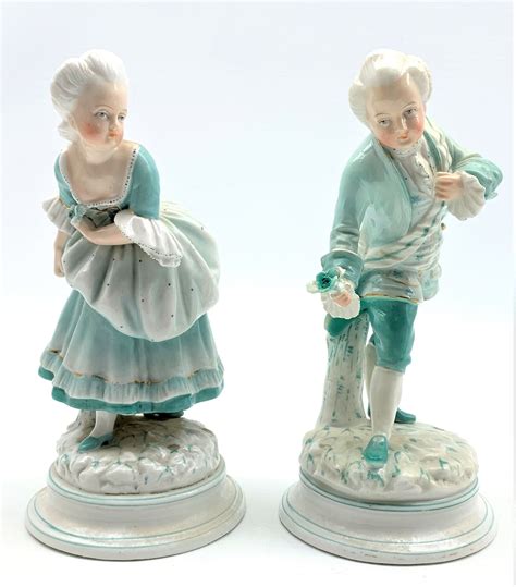 pair of 19th century porcelain male and female figures each holding a
