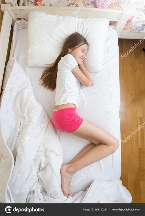 Вид сверху на девочек подростков в розовый пижамах спал на кровати — Стоковое фото © kryzhov