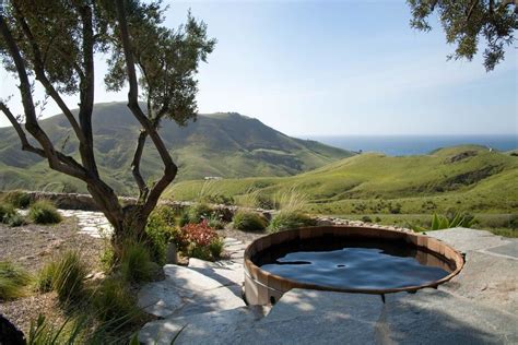 four person hot tub with rustic pool and cliffs with a