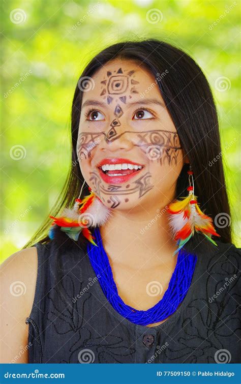 headshot mooie exotische vrouw uit de amazone met gezichtsverf en zwarte kleding stellende