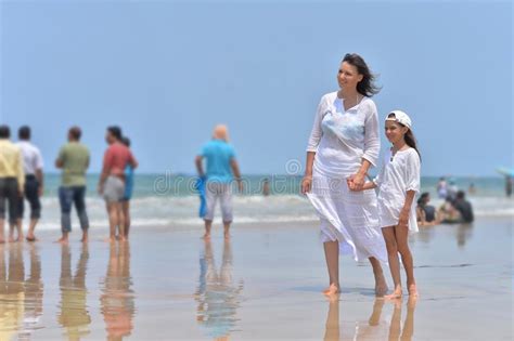 meisje die en op het strand golven lopen stock afbeelding