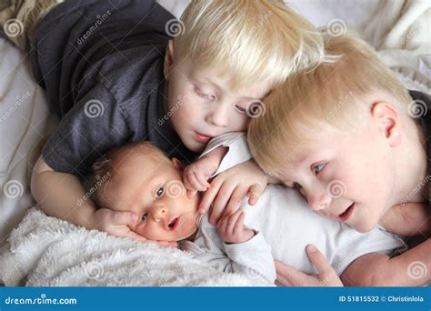 big brothers hugging newborn baby sister stock photo image