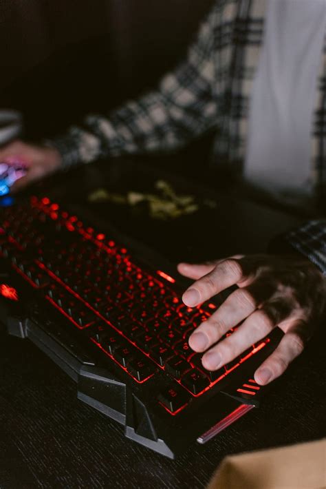 person holding red  black computer keyboard  stock photo