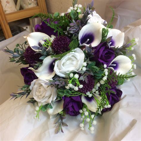 a wedding bouquet of white and purple silk flowers