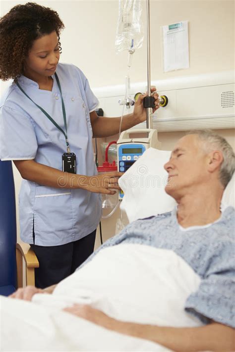 Nurse Adjusting Male Patient S Iv Drip In Hospital Stock