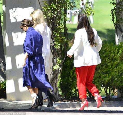 kim kardashian wears red trousers alongside kourtney and