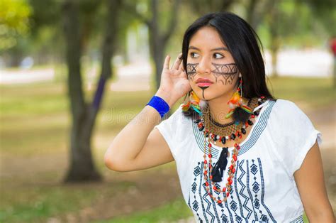 mooie vrouw uit de amazone met inheemse gezichtsverf en witte traditionele kleding die ernstige