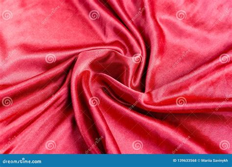 shining red silk atlas satin fabric  folds fabric waves real fabric background stock photo