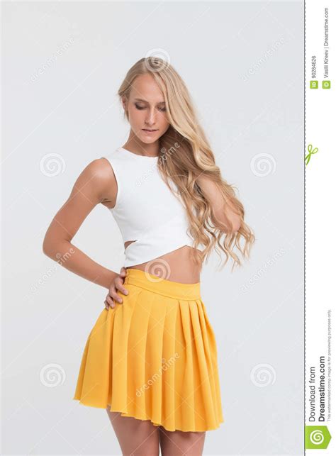 Girl With Perfect Body In Yellow Skirt On White Background