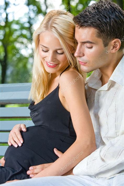 happy beautiful pregnant woman and her husband outdoors