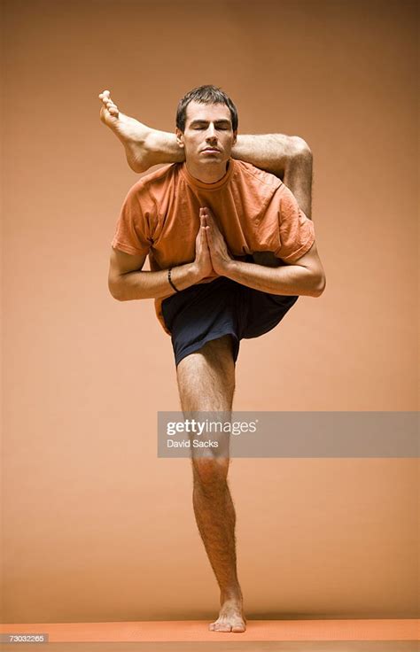 young man standing  leg  head  yoga pose front view high res stock photo getty images