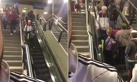 elderly couple try to walk down an upwards escalator