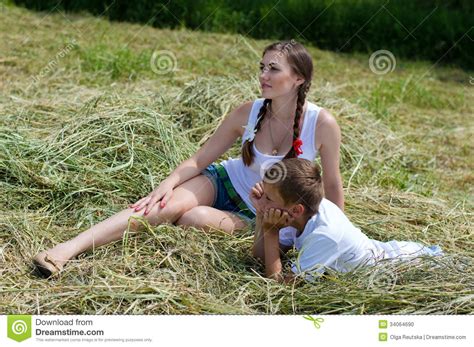 teenage sister and little brother sitting on hay stock