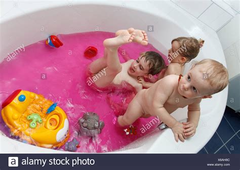 kinder spielen  der badewanne mit rosa wasser stockfoto bild