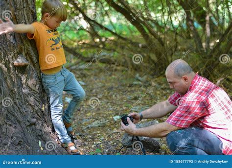 一个男人在大树的背景下，在森林里给一个男孩拍照 库存图片 图片 包括有 背包 查找 照相机 藏品 158677793
