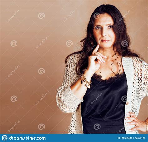 Pretty Brunette Confident Mature Woman Posing Cheerful On Warm Brown