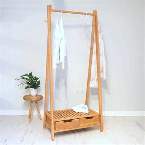 wooden bed frame  drawers  clothes hanging   wall
