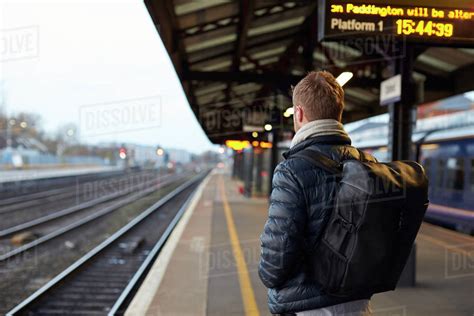 man standing  railway platform waiting  train  arrive stock photo dissolve
