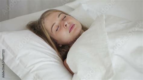 Pretty Girl Sleeping On Her Back In Bed Turning On Her Side And Smiling