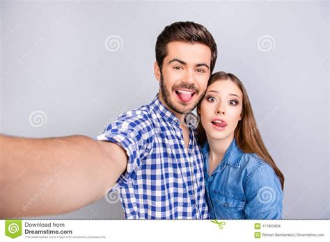 Funky Cheerful Young Couple Making Selfie Photo On Guy`s Camera Stock