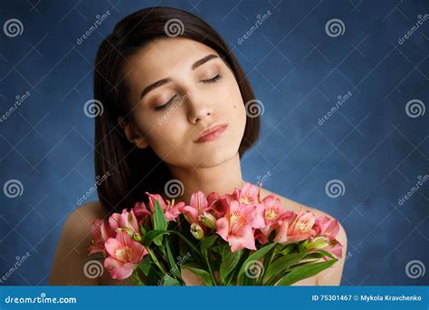 Close Up Portrait Of Tender Young Girl With Pink Flowers Over Blue