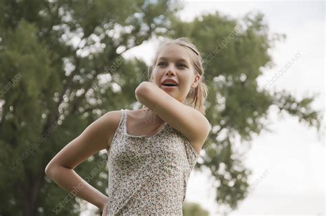 teenage girl rubbing her neck in park stock image f004 5091