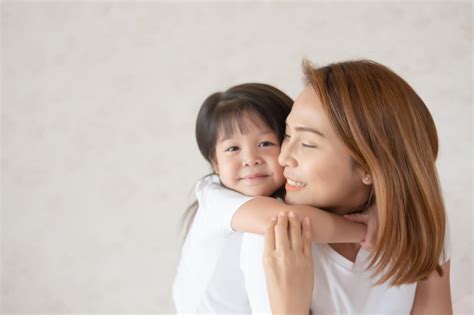 daughter hugging beautiful asian mother smile photo