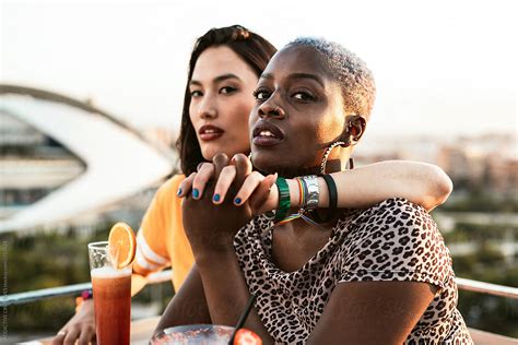 Multi Ethnic Lesbian Couple Relaxing With Cocktails By Addictive