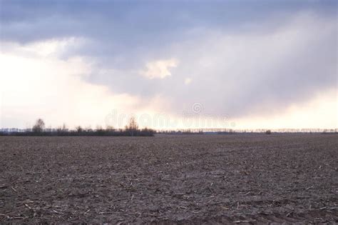 Cloudy Evening Sky Over A Plowed Farm Field Landscape Stock Image