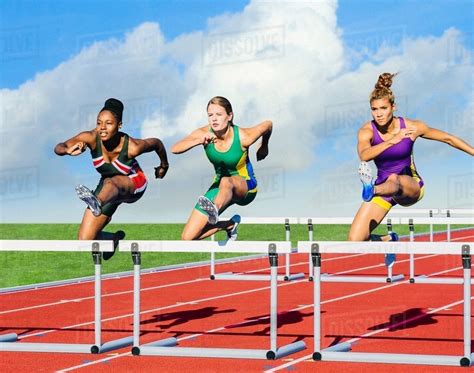 runners jumping  hurdle  track stock photo dissolve