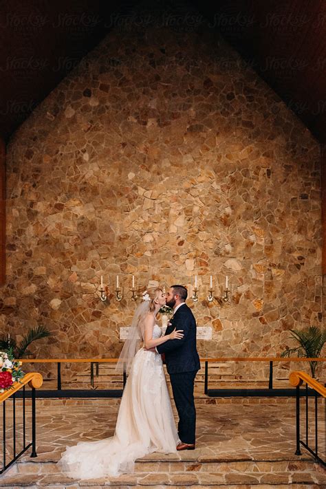 husband  wife sharing  kiss  wedding ceremony del colaborador de stocksy leah