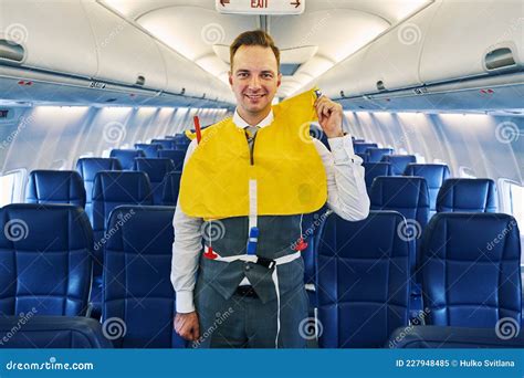 attractive male flight attendant   lifejacket   stock