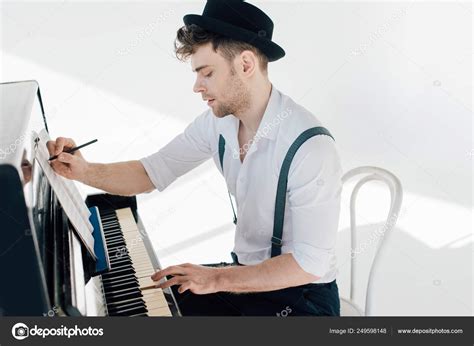 focused composer writing  book playing piano stock photo  allaserebrina