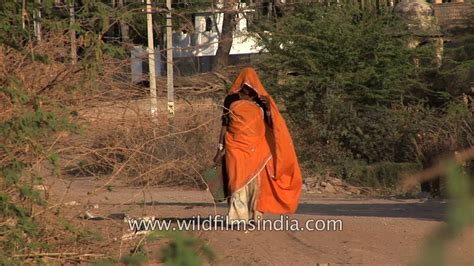 rajasthani woman veiled with her saree walks down deserted