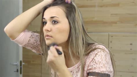 beauty teenage girl applying make up and admiring herself in the mirror beautiful teenager