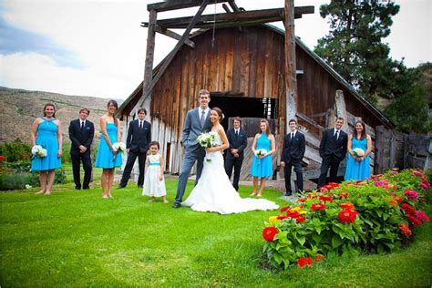 Bride And Groom Pose Outside Of Rustic Wedding Venue With