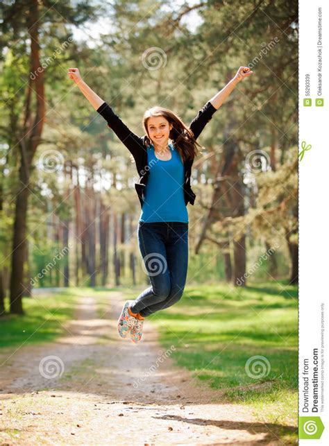happy girl jumps outdoors in a park vertical stock image image of