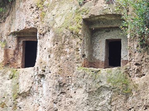 de rechthoekige ingangen aan etruscan graven sneden  de muur van een tufoklip stock afbeelding